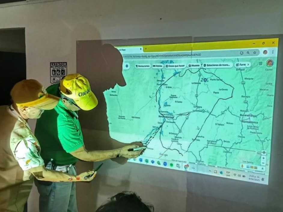 dos-hombres-con-cascos-amarillos-mirando-un-mapa-en-una-pantalla-grande