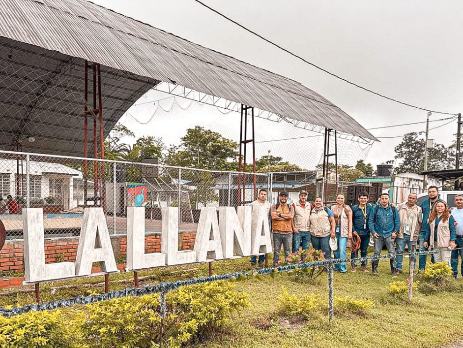 un-grupo-de-personas-parados-frente-a-un-letrero-que-dice-la-llama