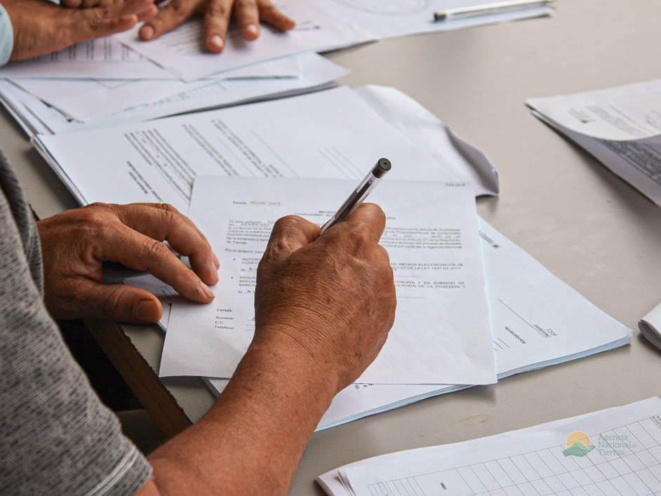 gente-sentada-en-una-mesa-con-papeles-y-bolgrafos