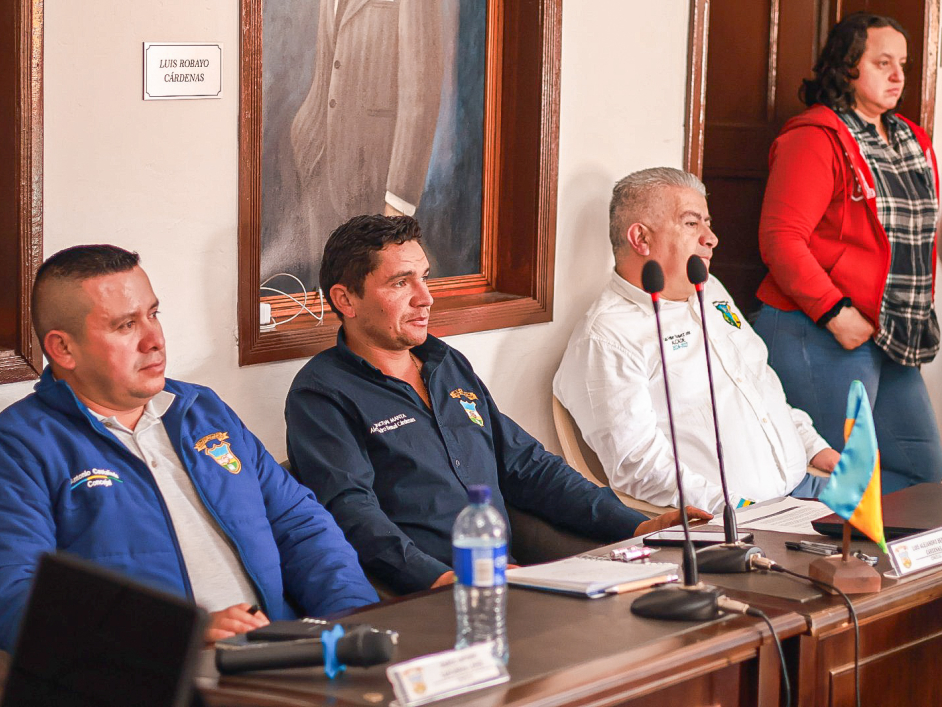 un-grupo-de-hombres-sentados-en-una-mesa-con-microfonos