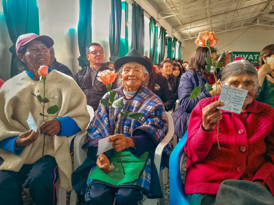 un-grupo-de-personas-mayores-sentadas-en-sillas-que-sostienen-flores
