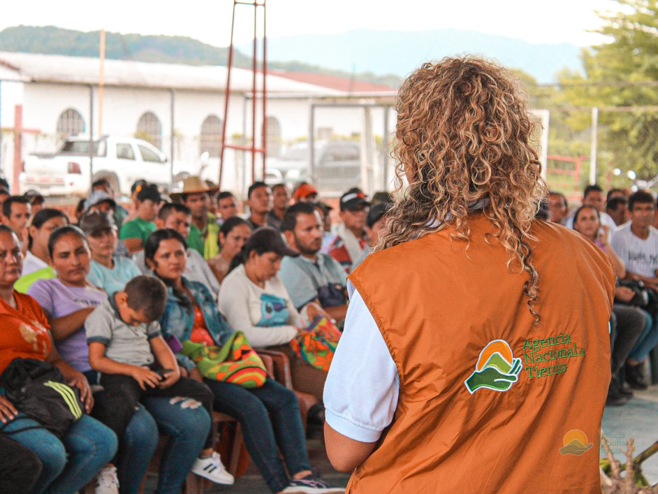 una-mujer-con-un-chaleco-naranja-est-hablando-con-una-multitud