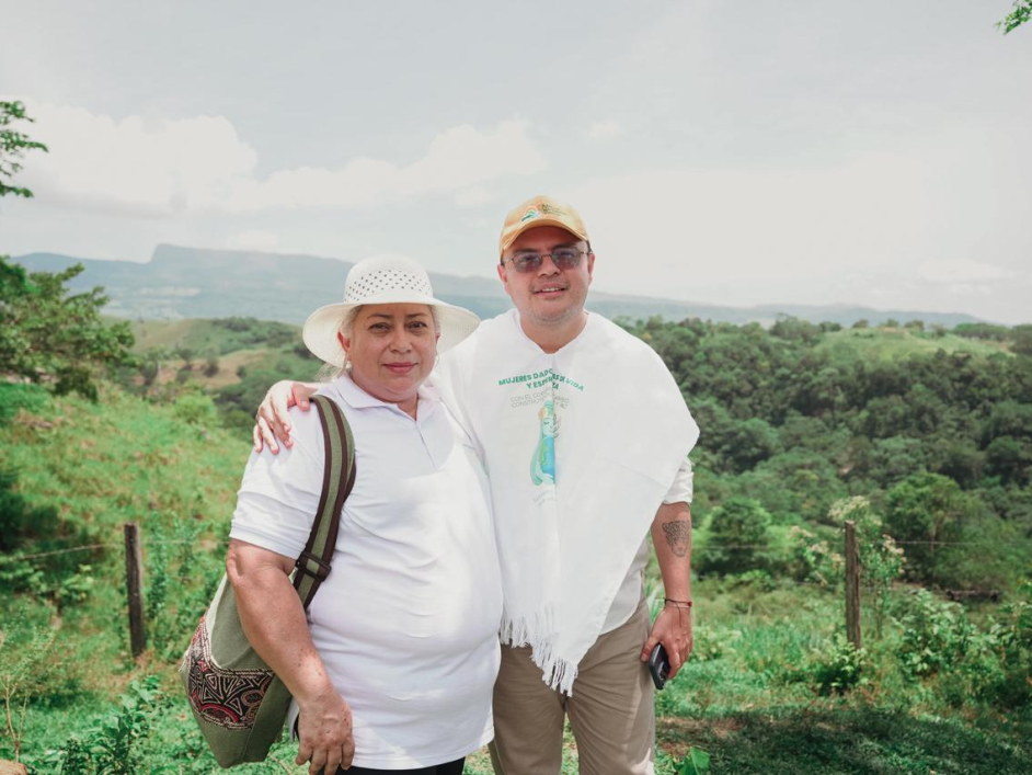 una-mujer-junto-a-director-ant-parados-frente-a-una-colina