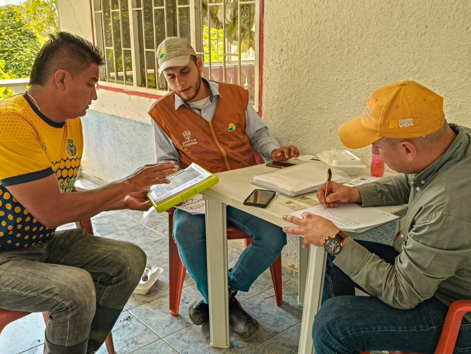 tres-hombres-sentados-en-una-mesa-con-papeles-y-boligrafo