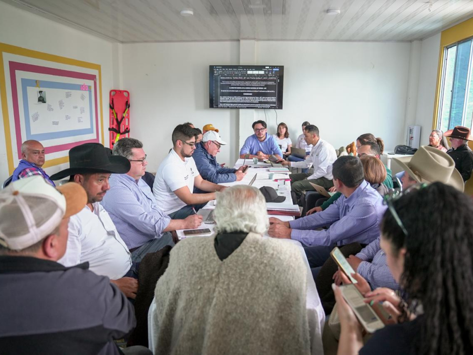 un-grupo-de-personas-sentadas-alrededor-de-una-mesa-con-papeles