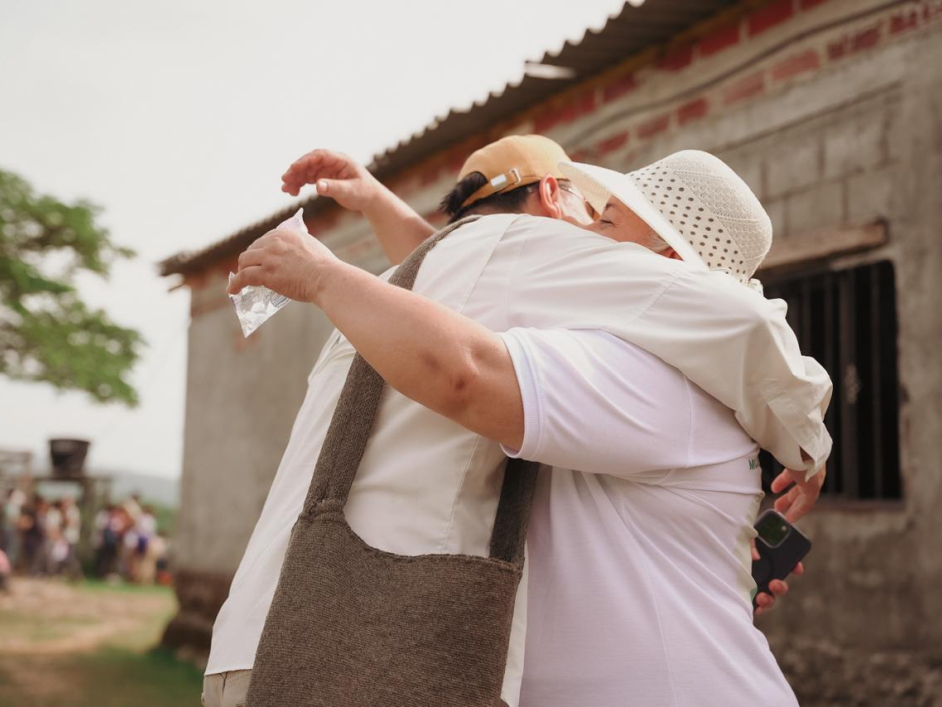 na-mujer-abrazando-a-director-ant-fuera-de-un-edificio