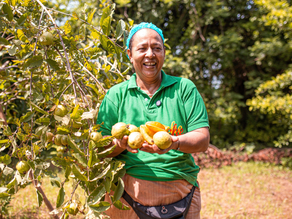 una-mujer-sosteniendo-un-monton-de-frutas-en-un-arbol.jpg
