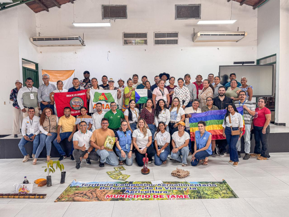 un-grupo-de-personas-posando-para-una-foto-frente-a-una-pancarta