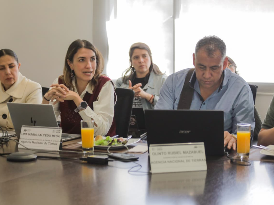 un-grupo-de-personas-sentadas-en-una-mesa-con-computadoras-portatiles