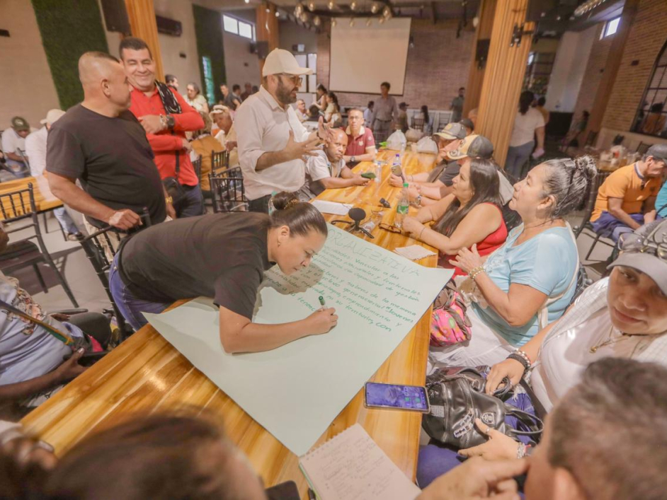 gente-sentada-alrededor-de-una-mesa-con-un-cartel