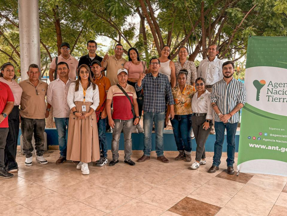 un-grupo-de-personas-paradas-frente-a-una-pancarta-de-ant